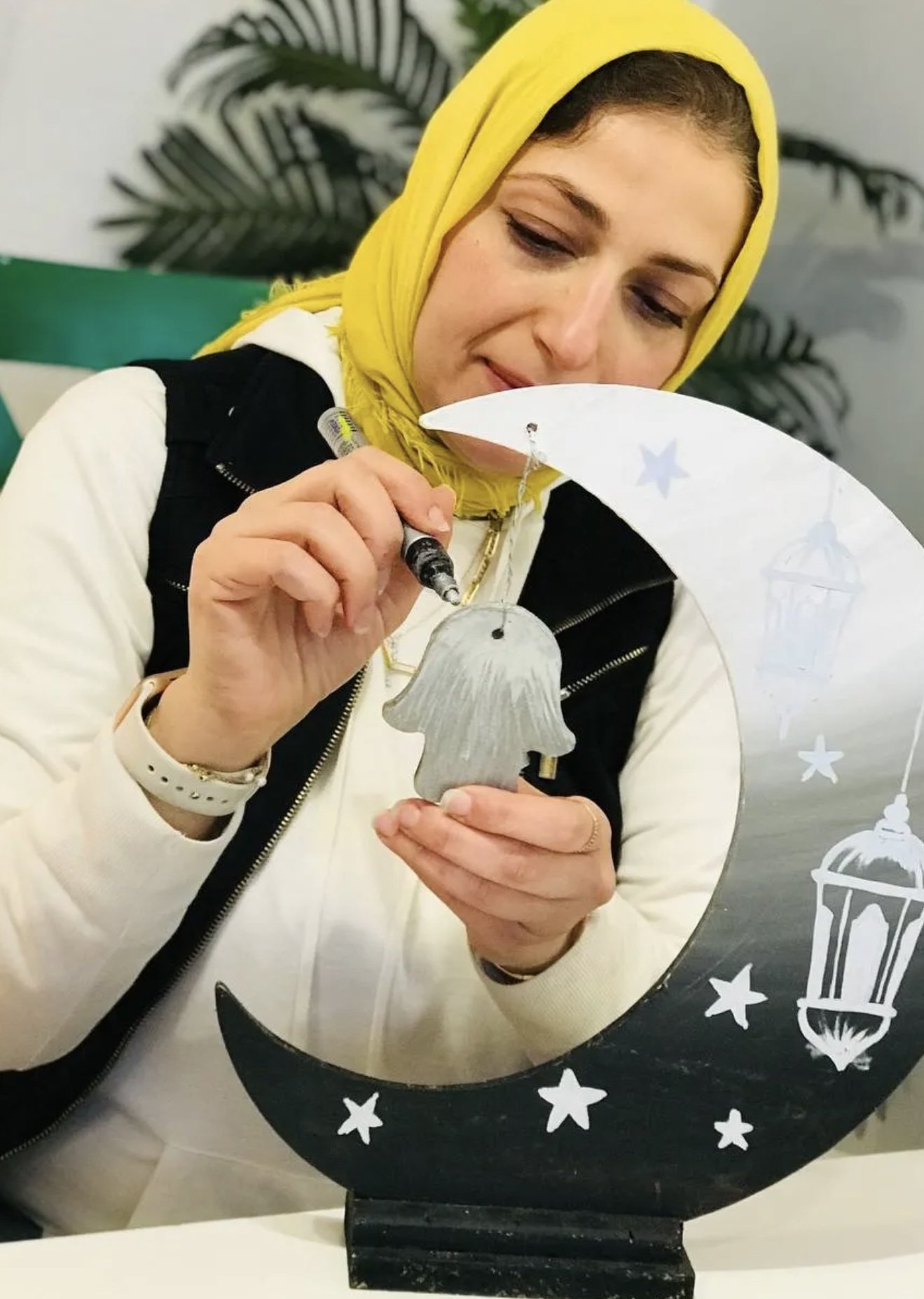 A student holding a watercolour painting of an old camera